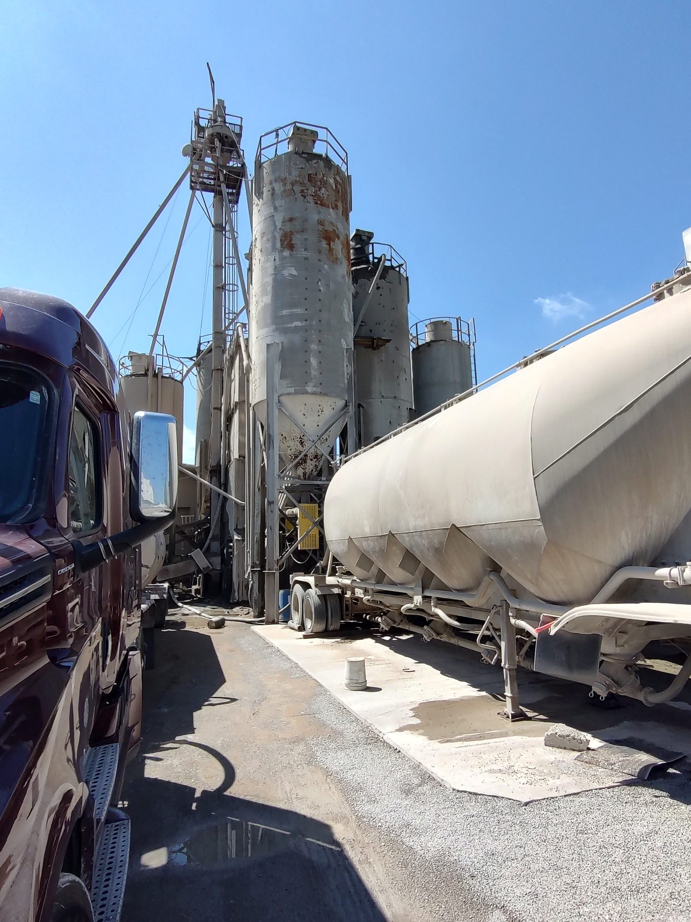 White pneumatic bulk trailer beside loading silos next to the GP National tractor